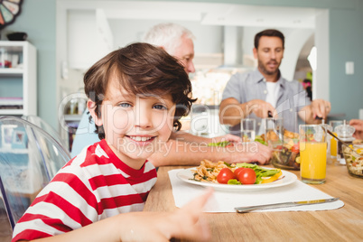 Portrait of smiling boy sitting at dining table