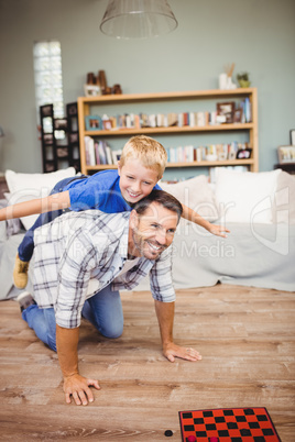 Happy father and son playing on hardwood floor
