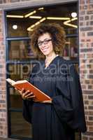 Lawyer standing near library with law book