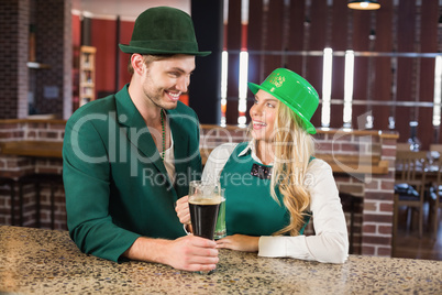 Man and woman looking at each other while holding beers