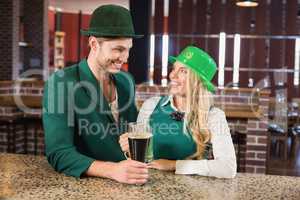 Man and woman looking at each other while holding beers