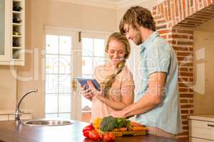 Cute couple cooking and using tablet