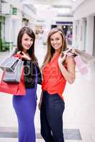 Portrait of two beautiful women shopping in mall