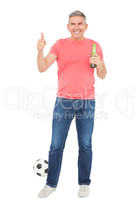 Handsome football fan drinking beer