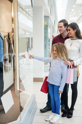 Happy family window shopping in mall