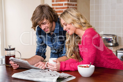 Cute couple reading the newspaper