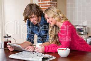 Cute couple reading the newspaper