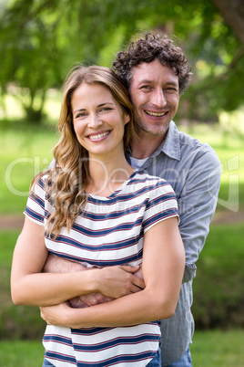 Smiling couple embracing in park