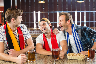 Men laughing with beers in hands