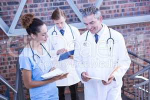 Doctors discussing medical report on staircase