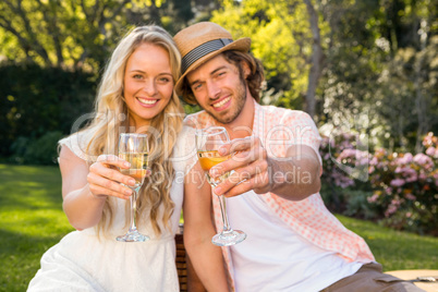 Happy couple having a picnic and drink champagne