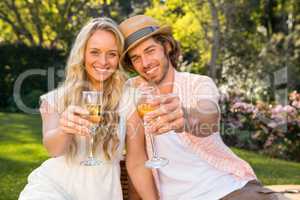 Happy couple having a picnic and drink champagne