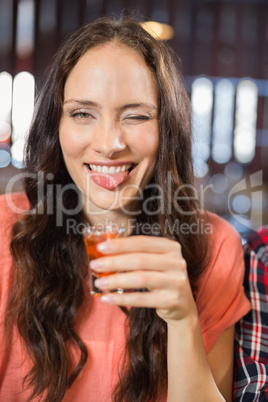 Woman looking at camera with shot in hand