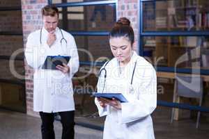 Female doctor using digital tablet near library