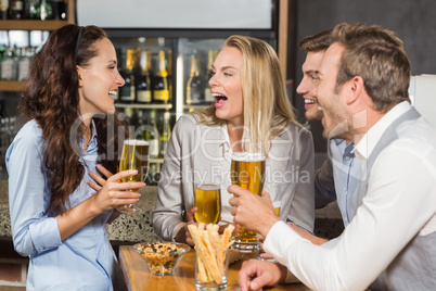 Friends laughing while drinking beer