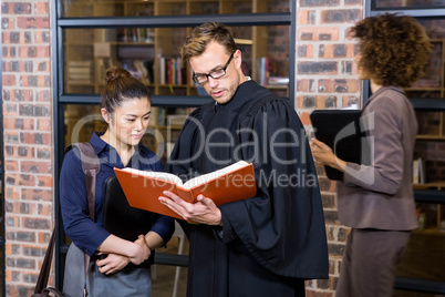 Lawyer and businesswoman reading law book