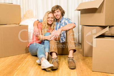 Happy couple sitting on the floor