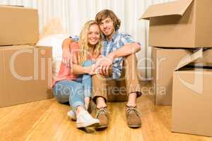 Happy couple sitting on the floor