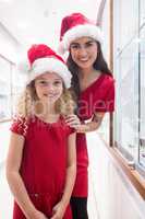 Mother and daughter in Christmas attire standing in jewelry shop