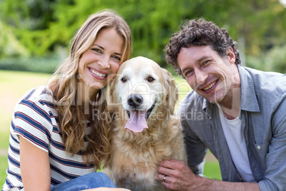 Smiling couple with dog in the park