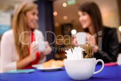 Packets of sugar in a cup on table