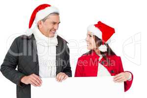 Festive couple with santa hat holding a white poster