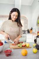 Happy woman cutting fruits