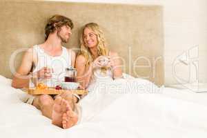 Cute couple having breakfast in bed