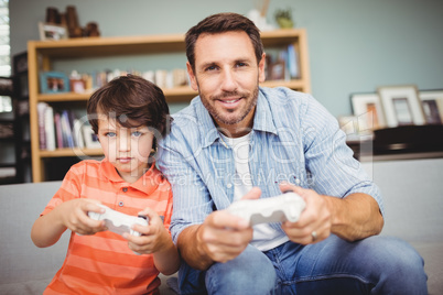 Smiling father and son playing video game