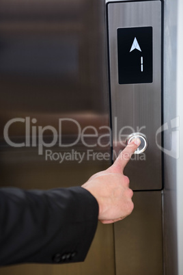 Businessman pressing elevator button