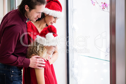Family in Christmas attire looking at a display