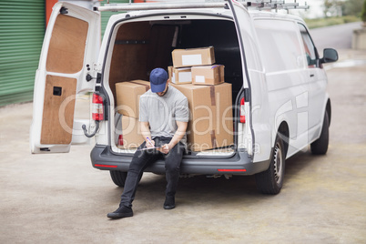 Delivery man writing on clipboard