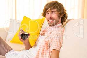 Handsome man enjoying a glass of wine on the couch