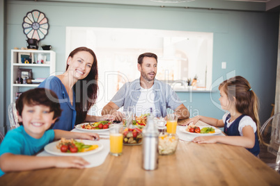 Smiling family with food on dining table