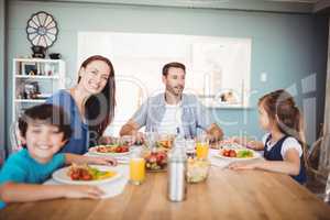Smiling family with food on dining table