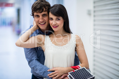 Portrait of couple embracing in mall