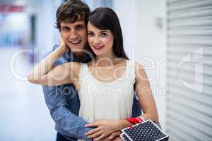 Portrait of couple embracing in mall