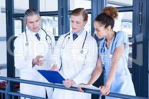 Doctors discussing medical report in corridor