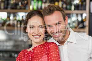 Couple smiling at camera while hugging