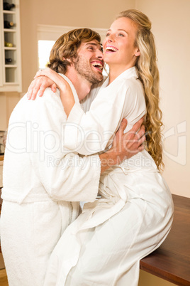 Cute couple cuddling with girlfriend sitting on the counter Cute couple cuddling with girlfriend sitting on the counter