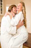 Cute couple cuddling with girlfriend sitting on the counter