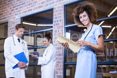 Female doctor checking a file near library