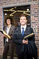 Lawyer and businesswoman standing near library with documents