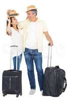 Happy couple embracing with straw hat and suitcase