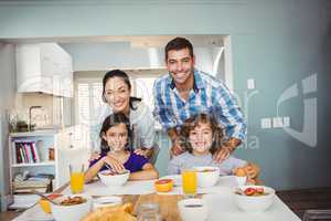 Happy man and woman with children having breakfast