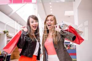 Portrait of two excited women with shopping bags