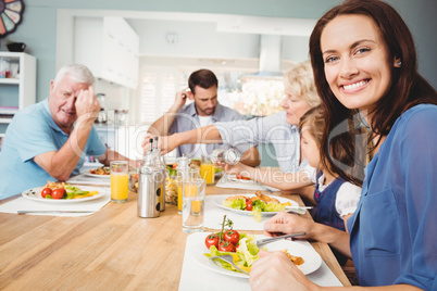 Portrait of smiling mother sitting at dining table