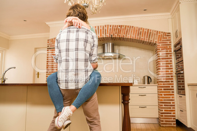 Cute couple cuddling with girlfriend sitting on the counter Cute couple cuddling with girlfriend sitting on the counter