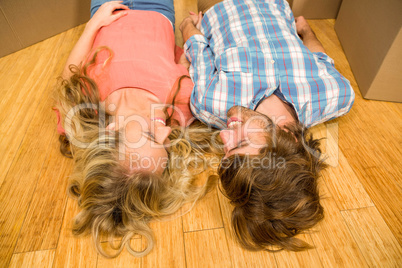 Happy couple lying on the floor