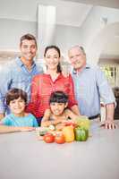 Happy family standing by kitchen table at home